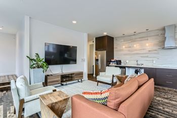 A living room with a television, a couch, and a chair.